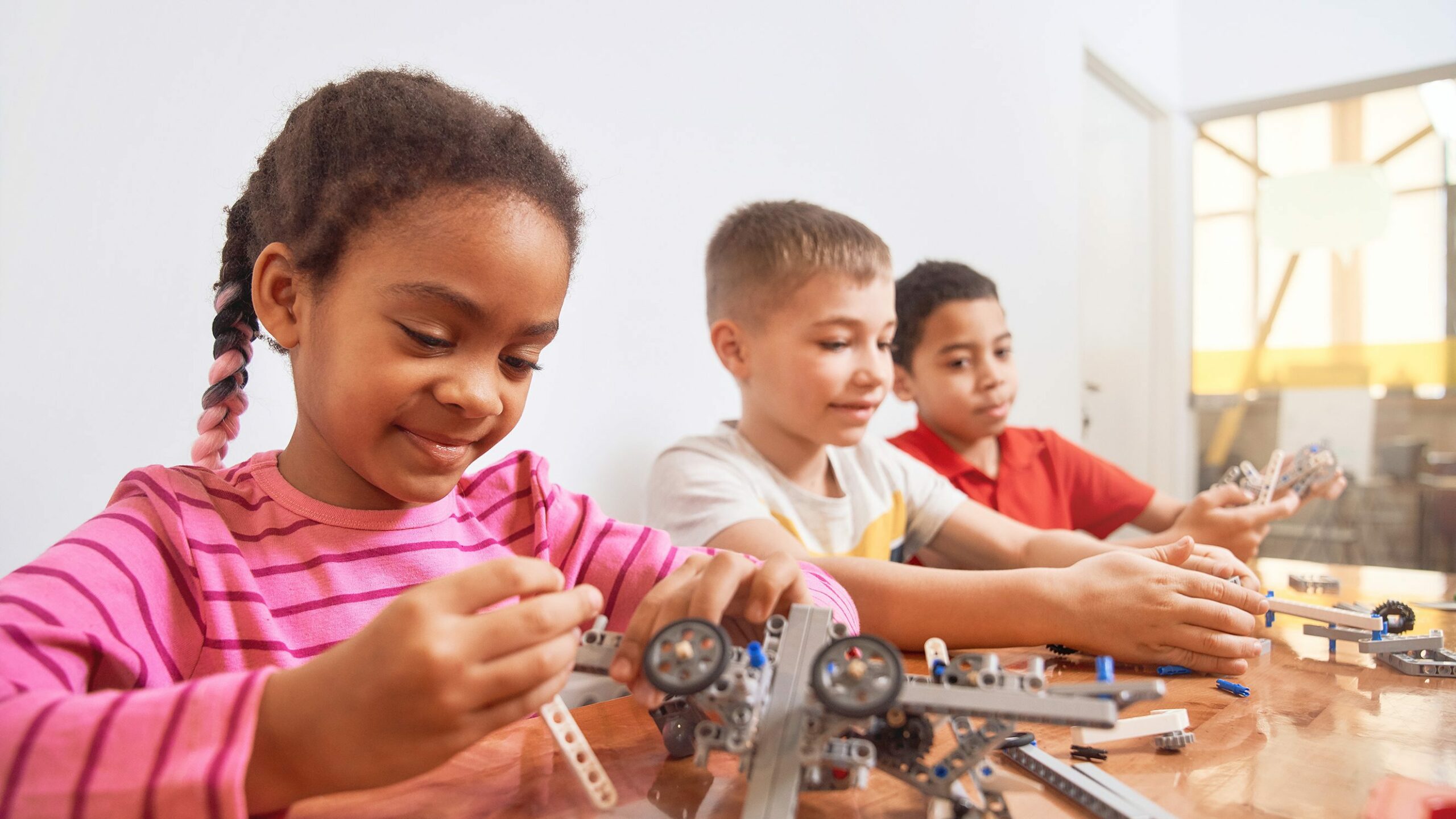 Multiracial kids using building kit.