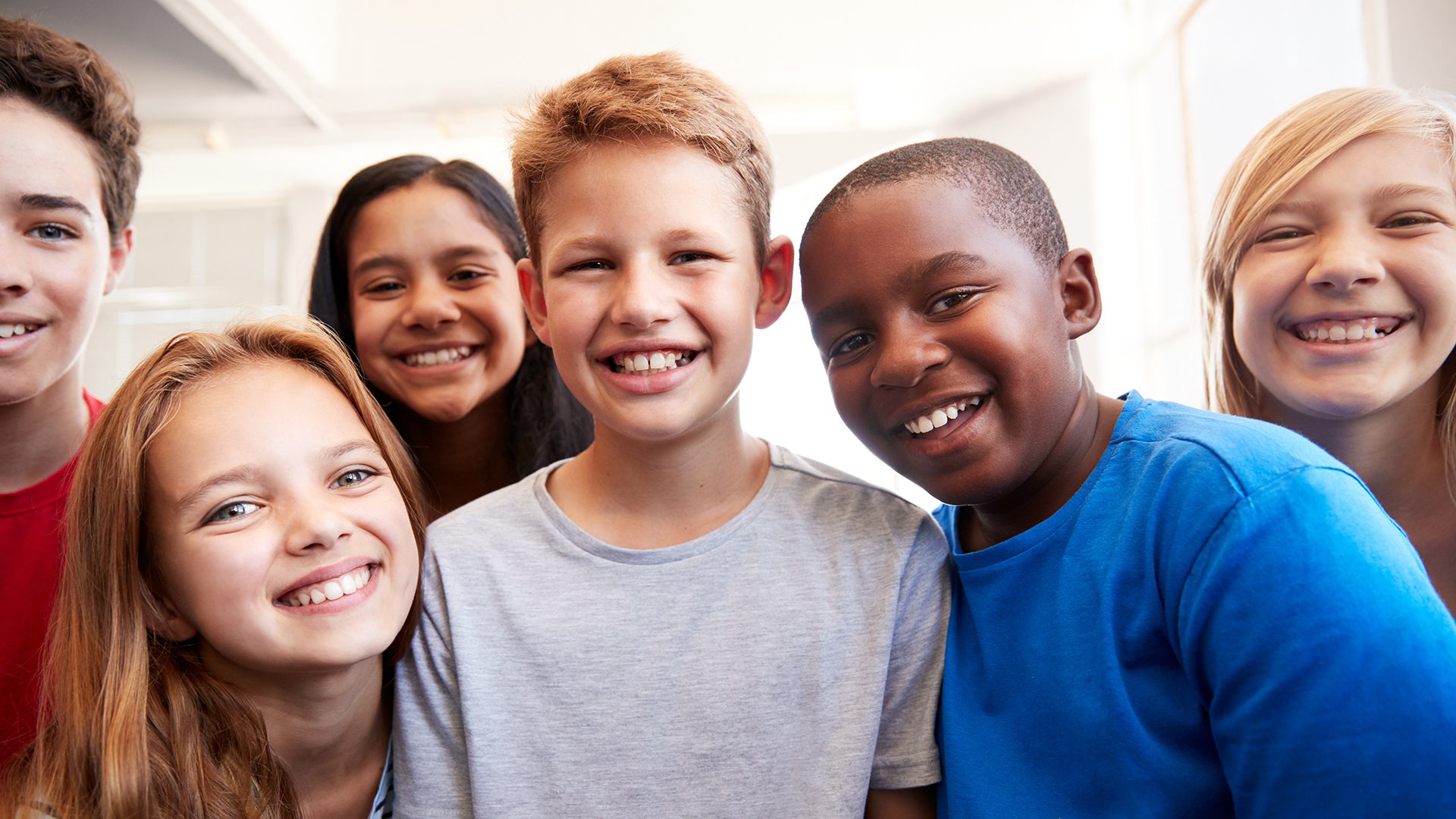 Portrait Of Smiling Male And Female Students In Grade School Classroom